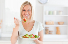 Woman eating a healthy meal of fresh vegetables and salad.